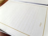 Image of gold lines writing paper set. Angled view of letter paper.